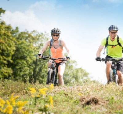 Pareja de ciclismo de montaña en senderos durante el verano