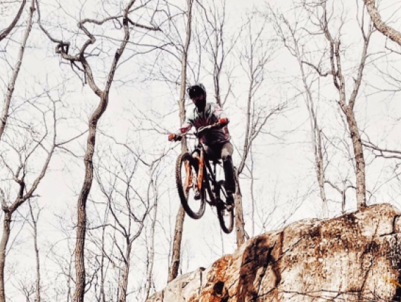 Un hombre saltando en bicicleta de montaña en el bosque (Instagram@weycyde)