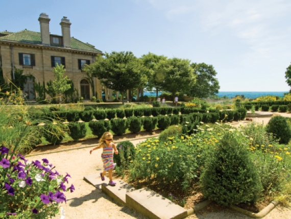 Niña corriendo frente a Harkness Mansion en Harkness Memorial State Park