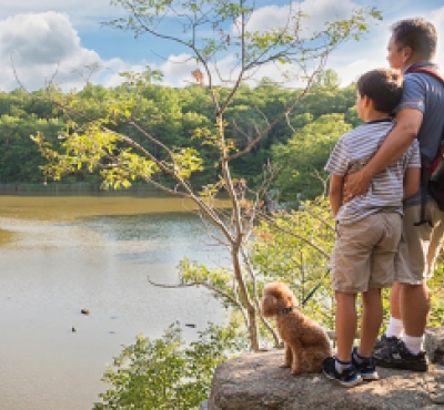 Hombre e hijo con su perro en la cima de una caminata en Guilford