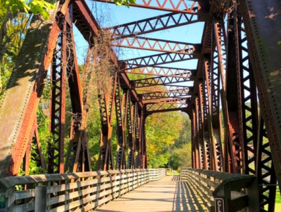 Un puente con estructura de metal y pasarela de madera.